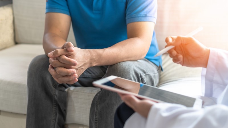 Partial picture of man on couch talking with doctor