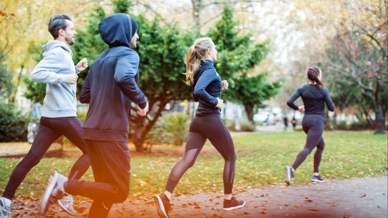 Four people running for exercise in a park.