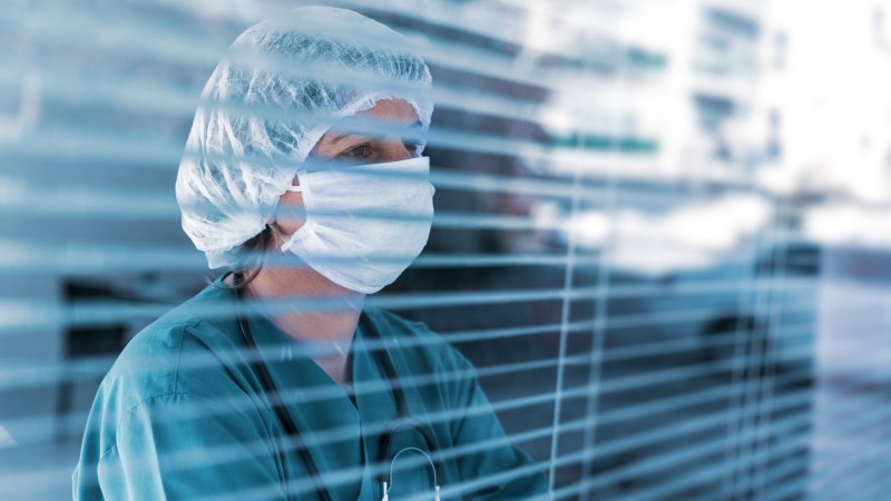 Worried doctor looking out window