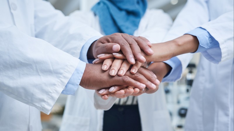 Close-up of hands on hands, medical teamwork concept 