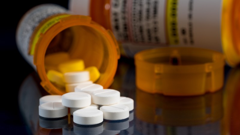 Closeup of prescription pills spilling out of pill bottle